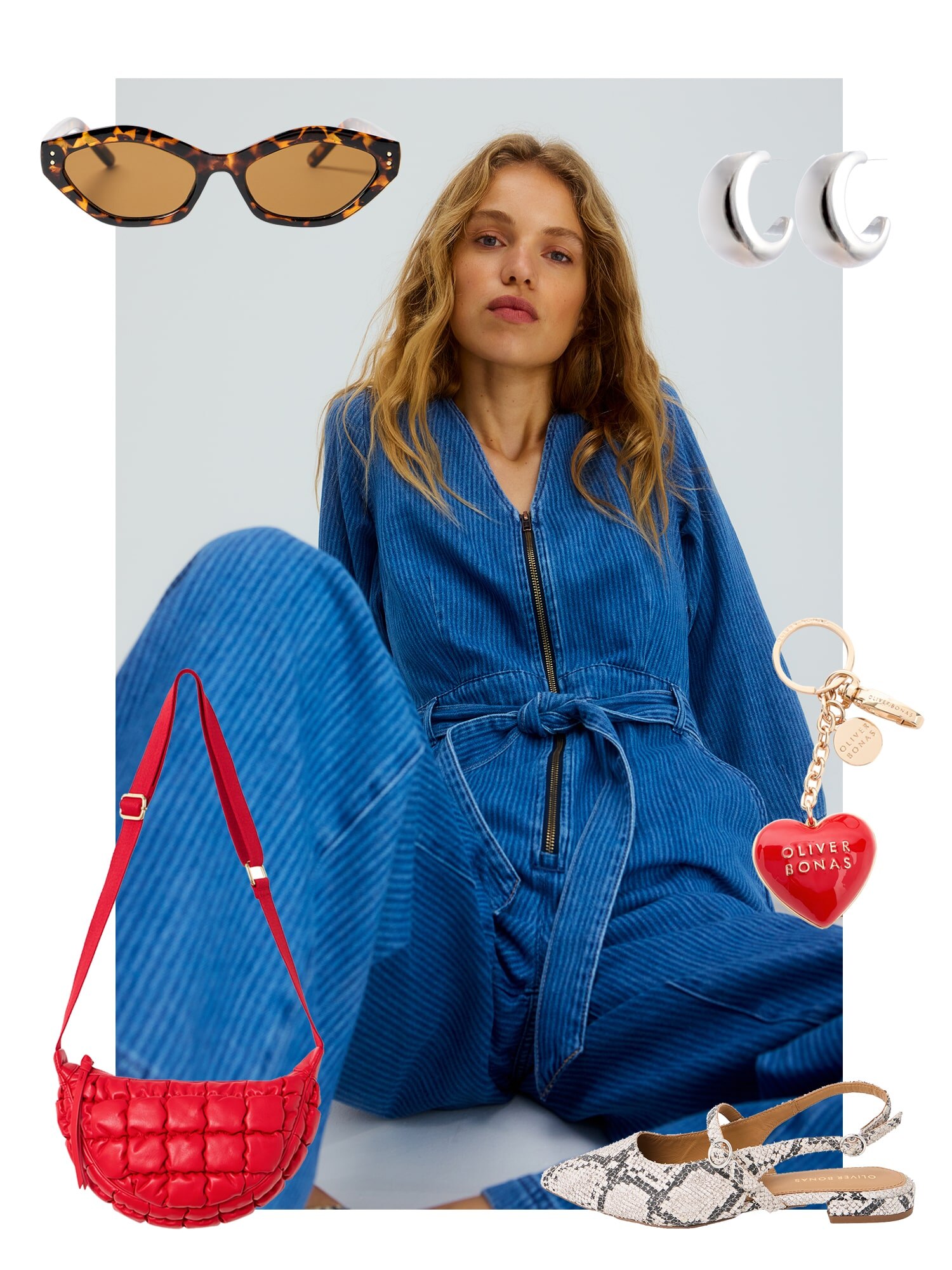 Model in a blue denim jumpsuit with snakeskin shoes, a red bag and silver earrings 