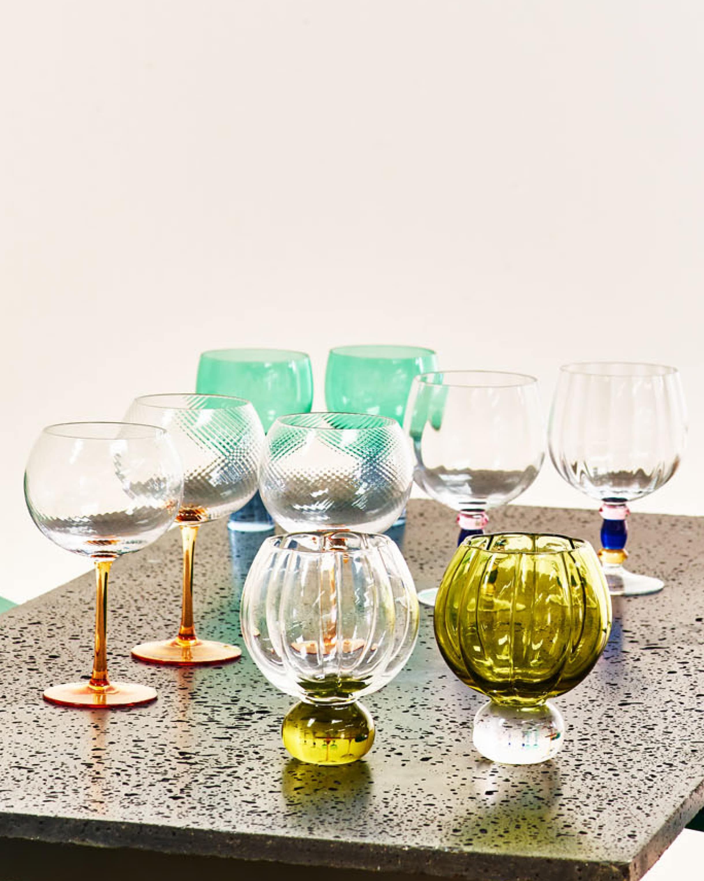 A collection of gin glasses on a dark table 