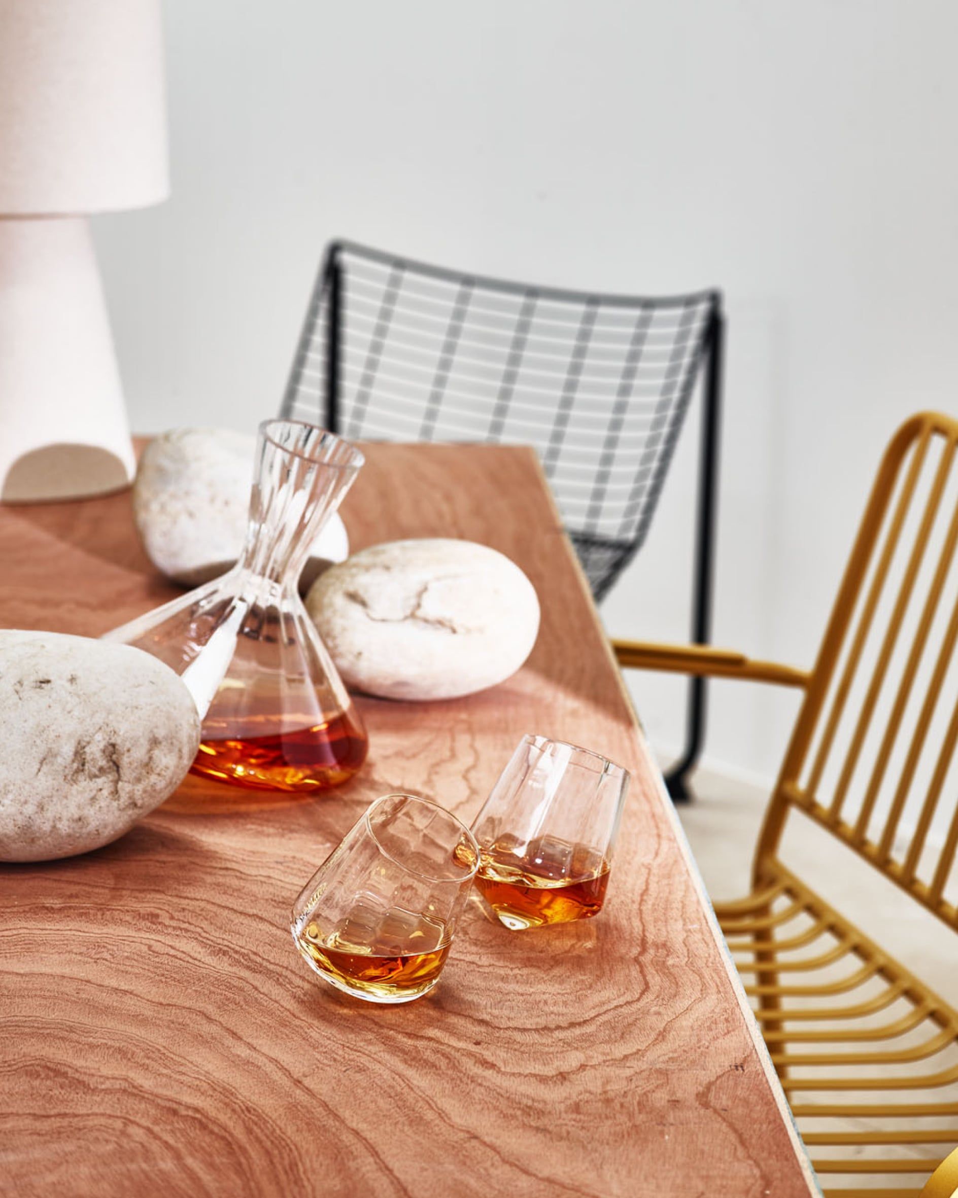 Two clear spinning whisky tumblers with a decanter 